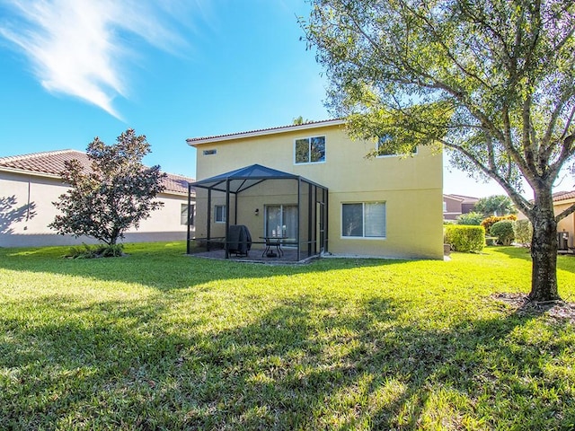 4368 56th Ln, Vero Beach, FL 32967 - rear view of house featuring a yard, stucco siding, a patio, and glass enclosure