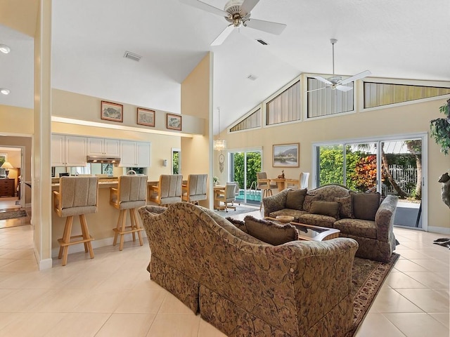 living room with ceiling fan, high vaulted ceiling, a healthy amount of sunlight, and light tile patterned floors