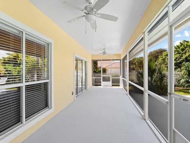 unfurnished sunroom with a wealth of natural light and ceiling fan