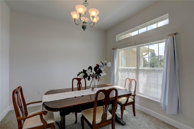 dining room with baseboards, an inviting chandelier, and light colored carpet
