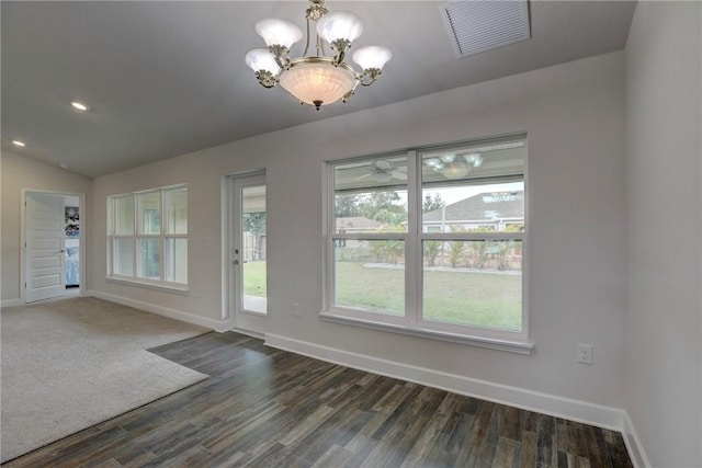 unfurnished dining area with an inviting chandelier, dark wood finished floors, baseboards, lofted ceiling, and visible vents