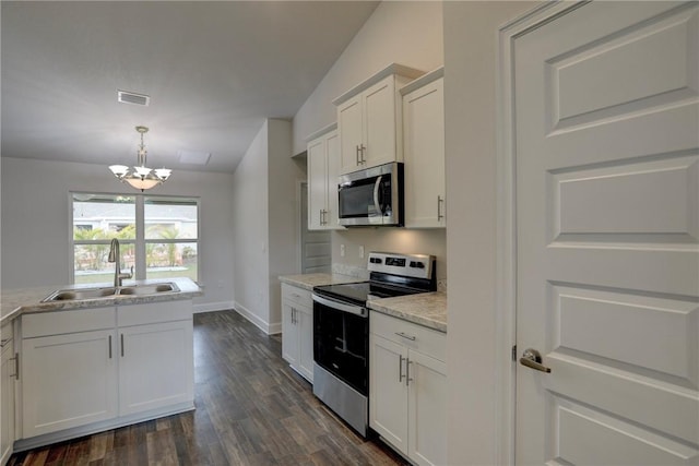 kitchen with dark wood-style flooring, a sink, an inviting chandelier, white cabinetry, and appliances with stainless steel finishes