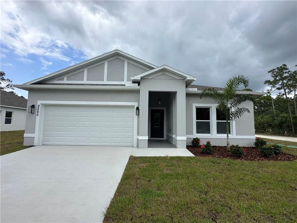 single story home featuring a garage, a front lawn, stucco siding, and driveway