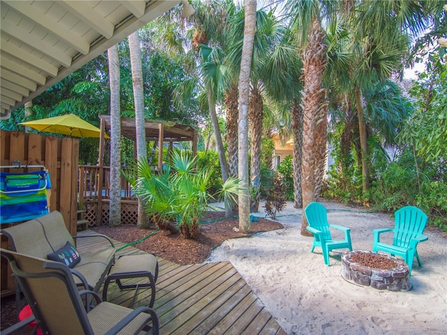 view of patio featuring a wooden deck and a fire pit