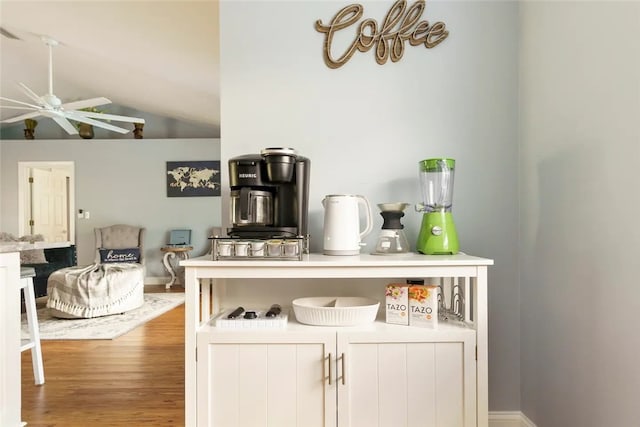 bar featuring white cabinetry, ceiling fan, lofted ceiling, and light wood-type flooring