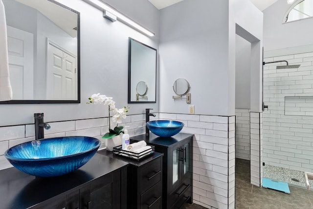 bathroom with tile walls, vanity, tile patterned floors, and tiled shower