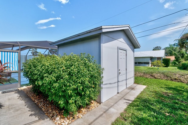 view of side of home with a yard and a lanai