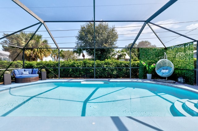 view of swimming pool featuring glass enclosure