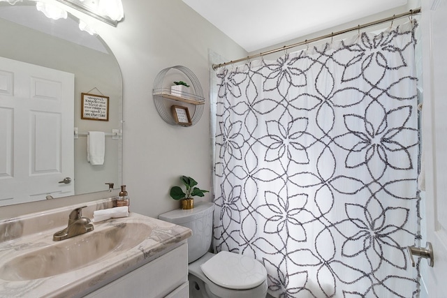 bathroom with walk in shower, vanity, and toilet