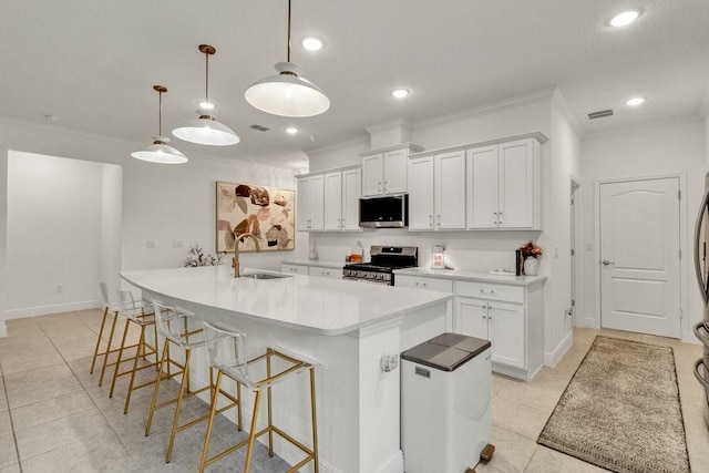 kitchen with visible vents, a sink, white cabinetry, appliances with stainless steel finishes, and crown molding