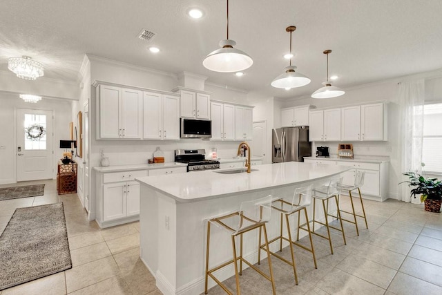 kitchen with a spacious island, visible vents, white cabinets, stainless steel appliances, and a sink