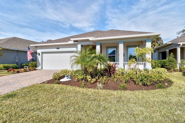 view of front of house featuring stucco siding, an attached garage, decorative driveway, and a front yard