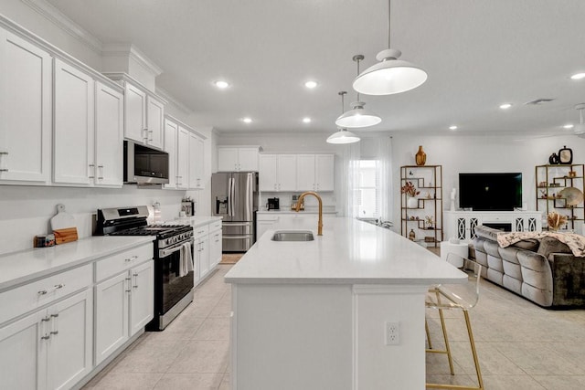 kitchen with light tile patterned flooring, an island with sink, a sink, stainless steel appliances, and open floor plan