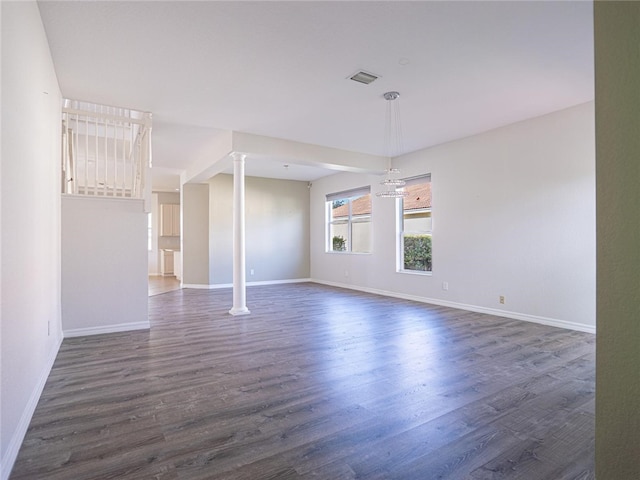 empty room with dark hardwood / wood-style floors and a notable chandelier