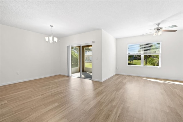 spare room with ceiling fan with notable chandelier, a textured ceiling, and light wood-type flooring