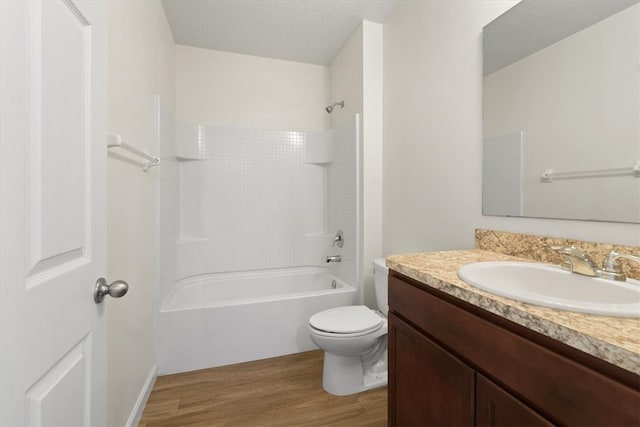 full bathroom with bathtub / shower combination, vanity, a textured ceiling, hardwood / wood-style floors, and toilet