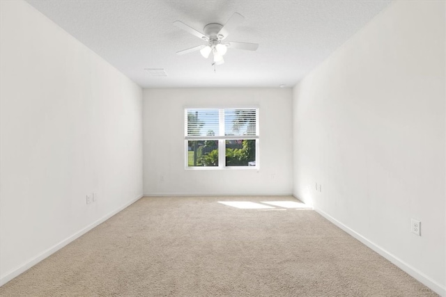 carpeted spare room featuring ceiling fan and a textured ceiling