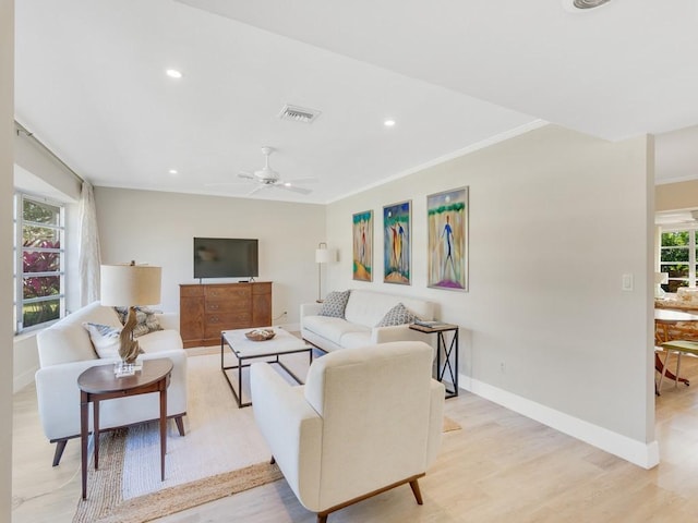 living room featuring ceiling fan, light hardwood / wood-style floors, and ornamental molding