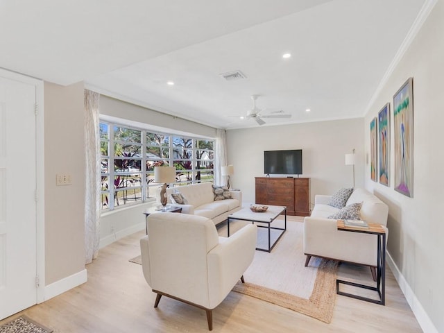 living room featuring ceiling fan, crown molding, and light hardwood / wood-style flooring