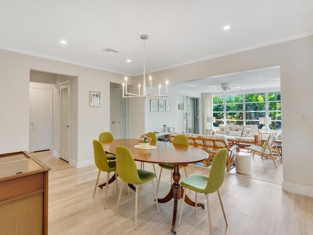 dining space with ceiling fan with notable chandelier, ornamental molding, and light hardwood / wood-style flooring