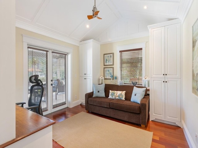 living area featuring vaulted ceiling with beams, wood finished floors, a ceiling fan, and baseboards