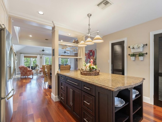 kitchen featuring dark wood-type flooring, visible vents, dark brown cabinets, open shelves, and stainless steel fridge