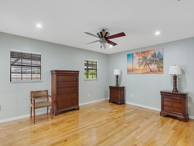 living area with ceiling fan and light hardwood / wood-style floors