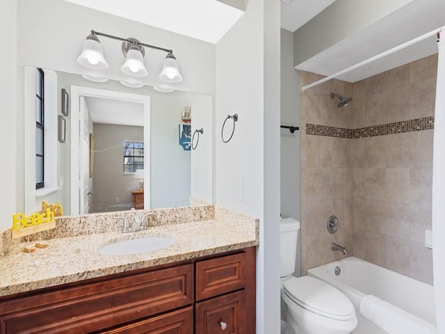 full bathroom with tiled shower / bath combo, vanity, and toilet