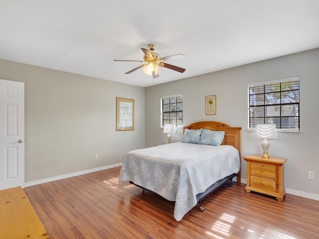 bedroom with multiple windows, hardwood / wood-style floors, and ceiling fan