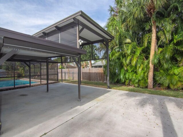 view of patio featuring a fenced in pool and glass enclosure