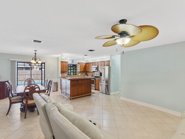 living room with ceiling fan with notable chandelier and light tile patterned floors