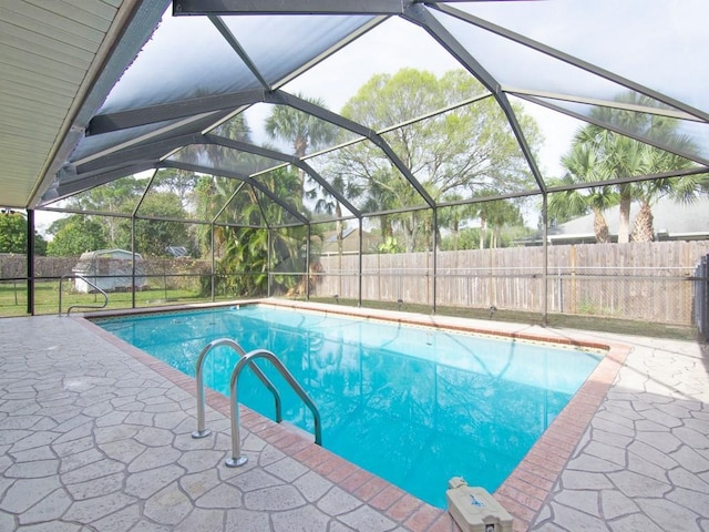 view of swimming pool featuring a lanai and a patio area