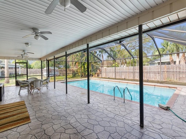 view of swimming pool featuring a patio area, ceiling fan, and glass enclosure