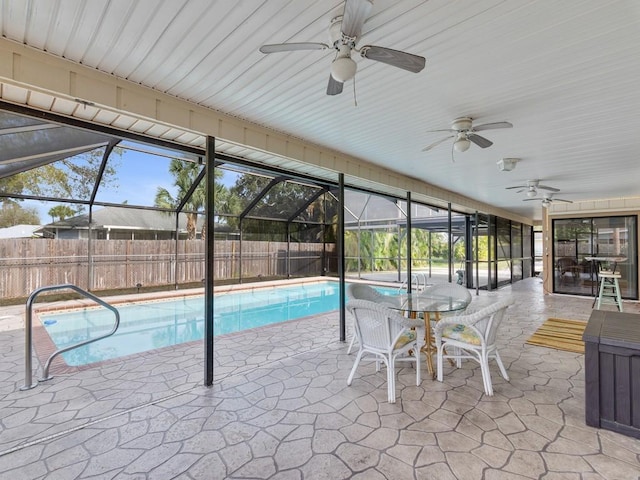 view of swimming pool with a patio area, ceiling fan, and glass enclosure