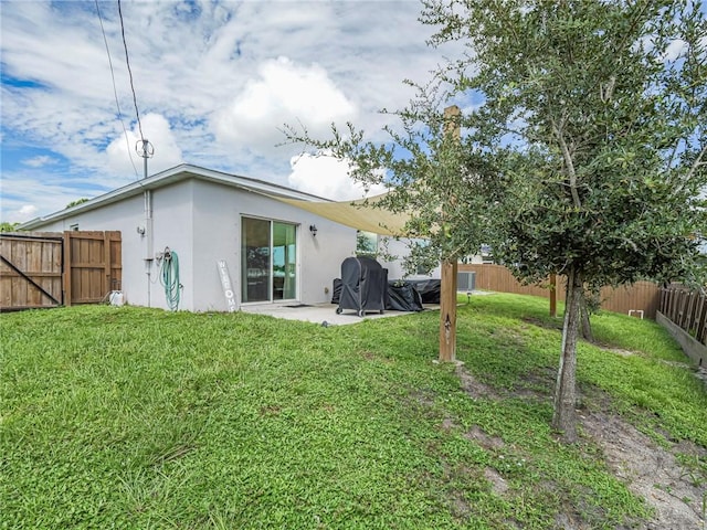 back of house featuring a patio and a yard