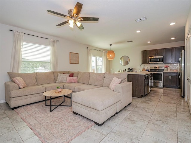 tiled living room with sink and ceiling fan