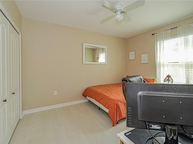 bedroom featuring ceiling fan, a closet, and light wood-type flooring