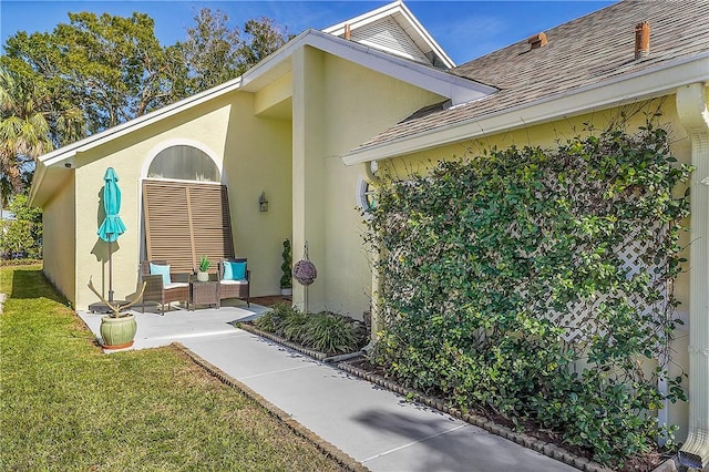 entrance to property featuring a patio and a yard