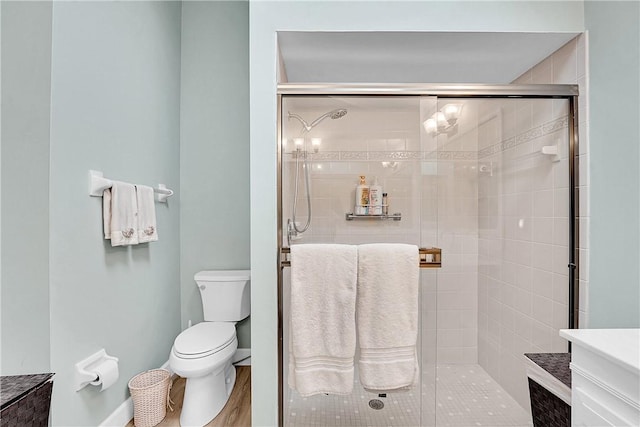 bathroom featuring a shower with shower door, wood-type flooring, and toilet