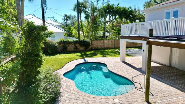 view of pool with a yard, a deck, and a patio area