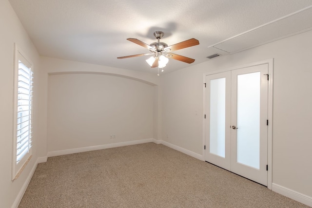 carpeted spare room featuring french doors and ceiling fan