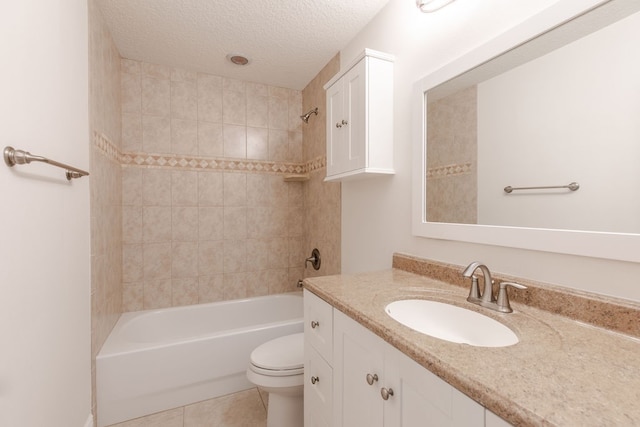 full bathroom featuring vanity, tile patterned floors, tiled shower / bath, toilet, and a textured ceiling