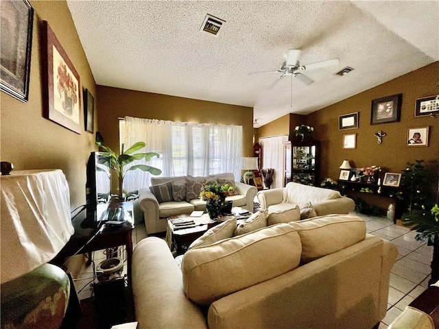 living room featuring vaulted ceiling, light tile patterned floors, a textured ceiling, and ceiling fan