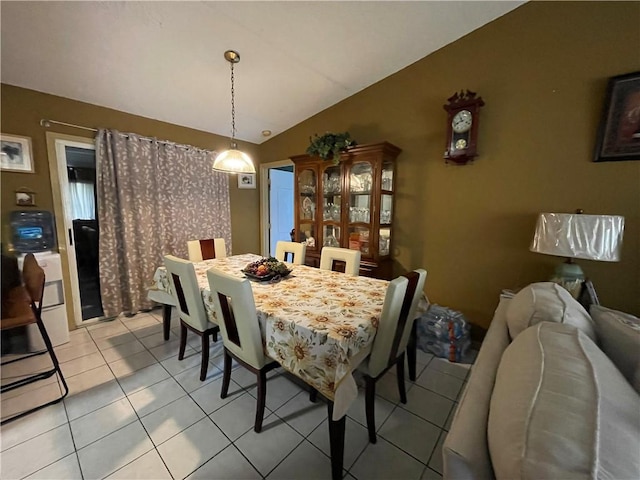 tiled dining space featuring lofted ceiling