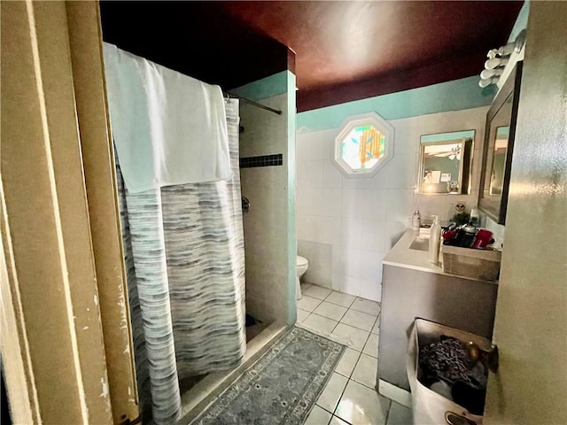 bathroom featuring toilet, tile walls, vanity, a shower with shower curtain, and tile patterned flooring