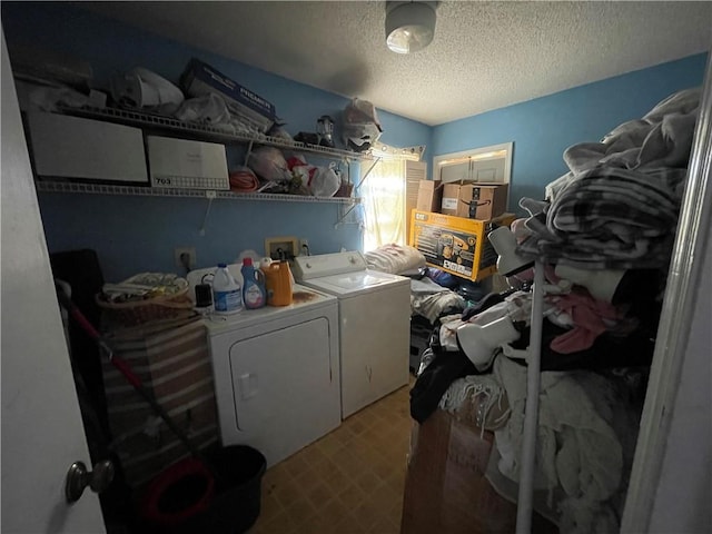 laundry area with washing machine and clothes dryer and a textured ceiling