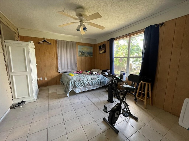 tiled bedroom with ceiling fan, crown molding, a textured ceiling, and wood walls