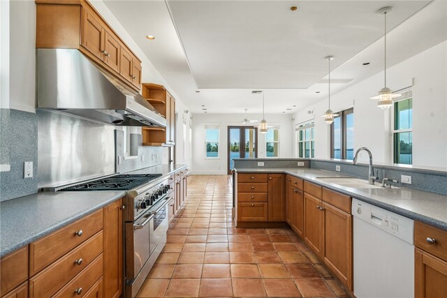 kitchen featuring white dishwasher, sink, tasteful backsplash, stainless steel stove, and decorative light fixtures