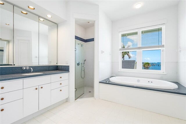 bathroom with independent shower and bath, tile patterned flooring, and vanity