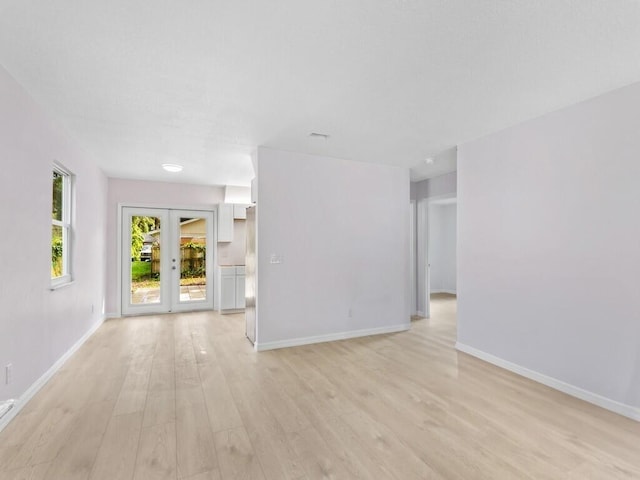 spare room with french doors and light wood-type flooring